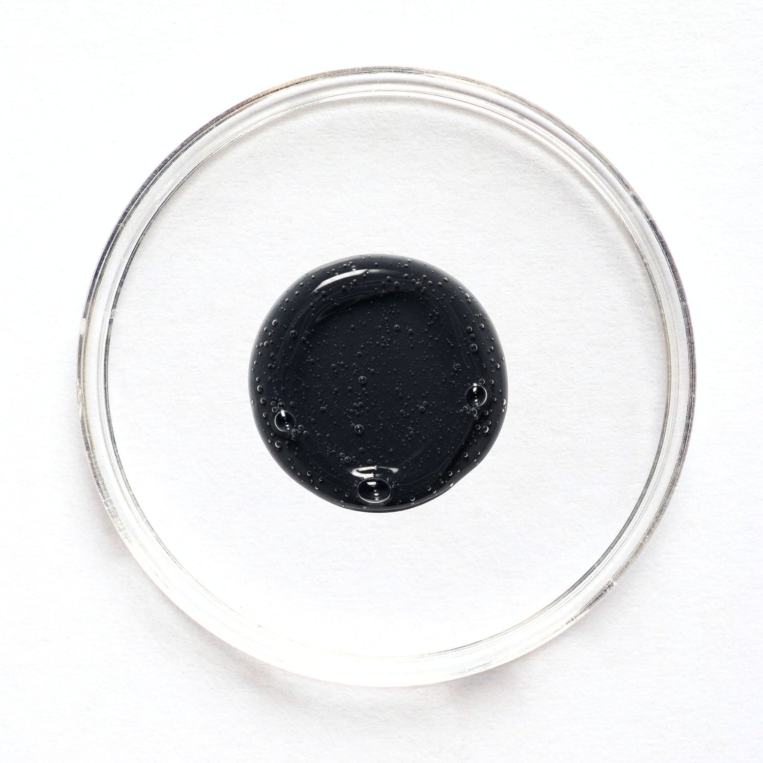 Feliks face cleanser sample in a glass petri dish on a white background