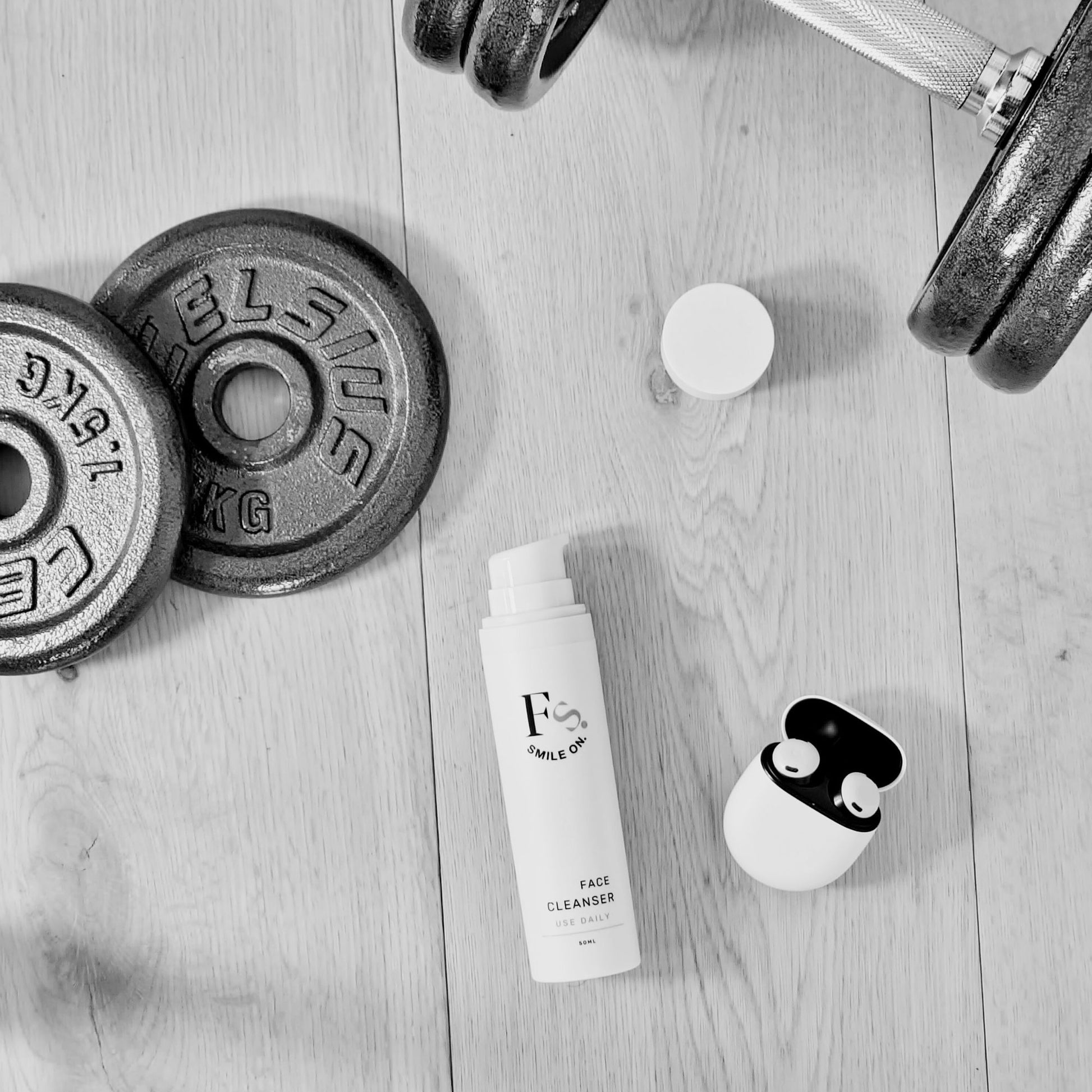 Feliks skincare products on a wooden surface with weights in the background