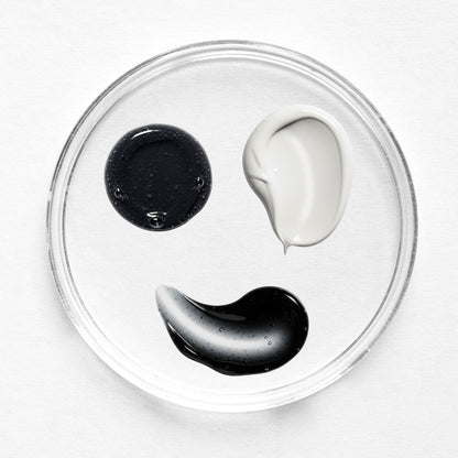 The image shows three Feliks skin care swatches. At the top of the image is a white smear labelled daily moisturiser. In the middle is a black textured smear labelled charcoal cleanser. At the bottom is a black smooth smear labelled charcoal exfoliator.