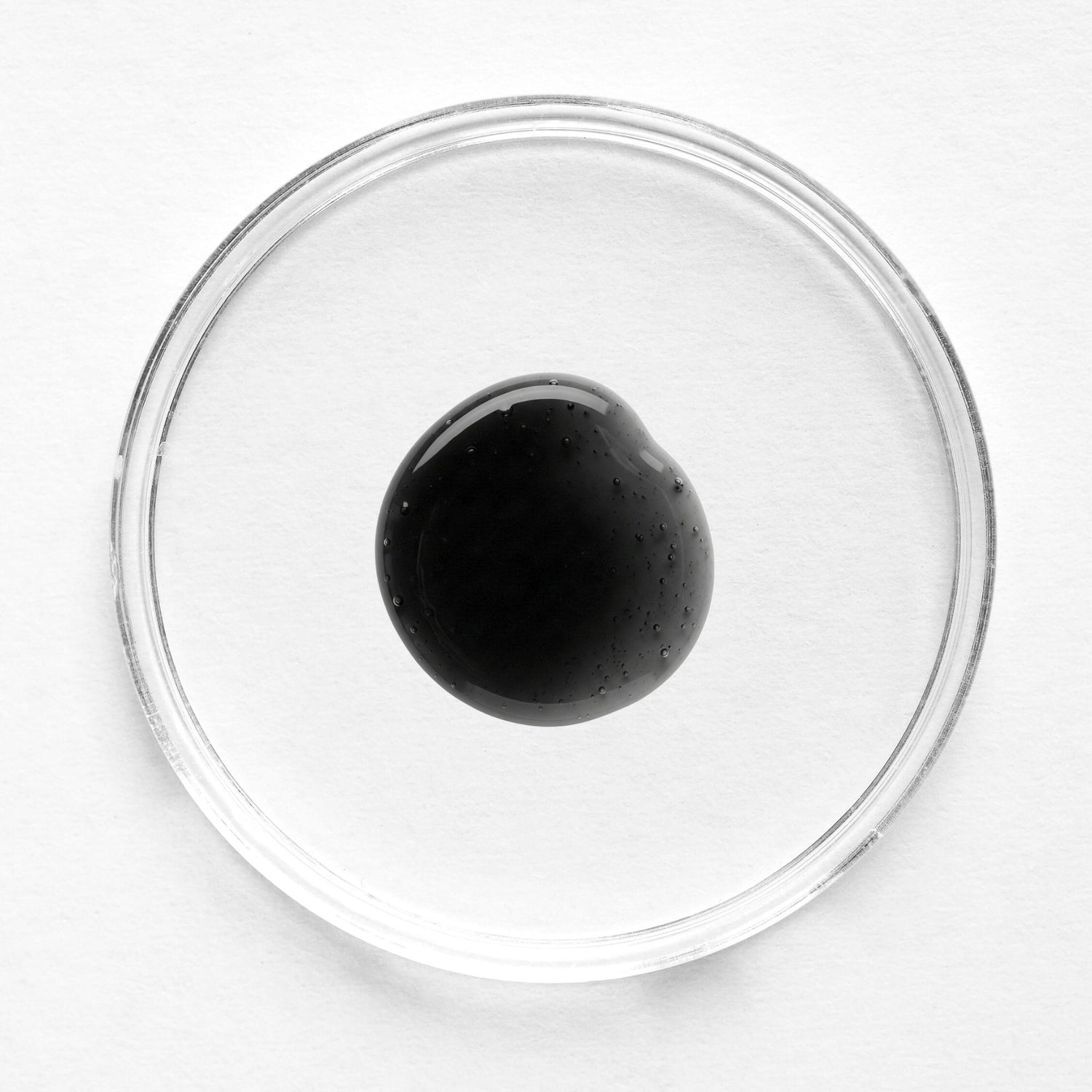 Feliks renewal exfoliator in a glass petri dish on a white background