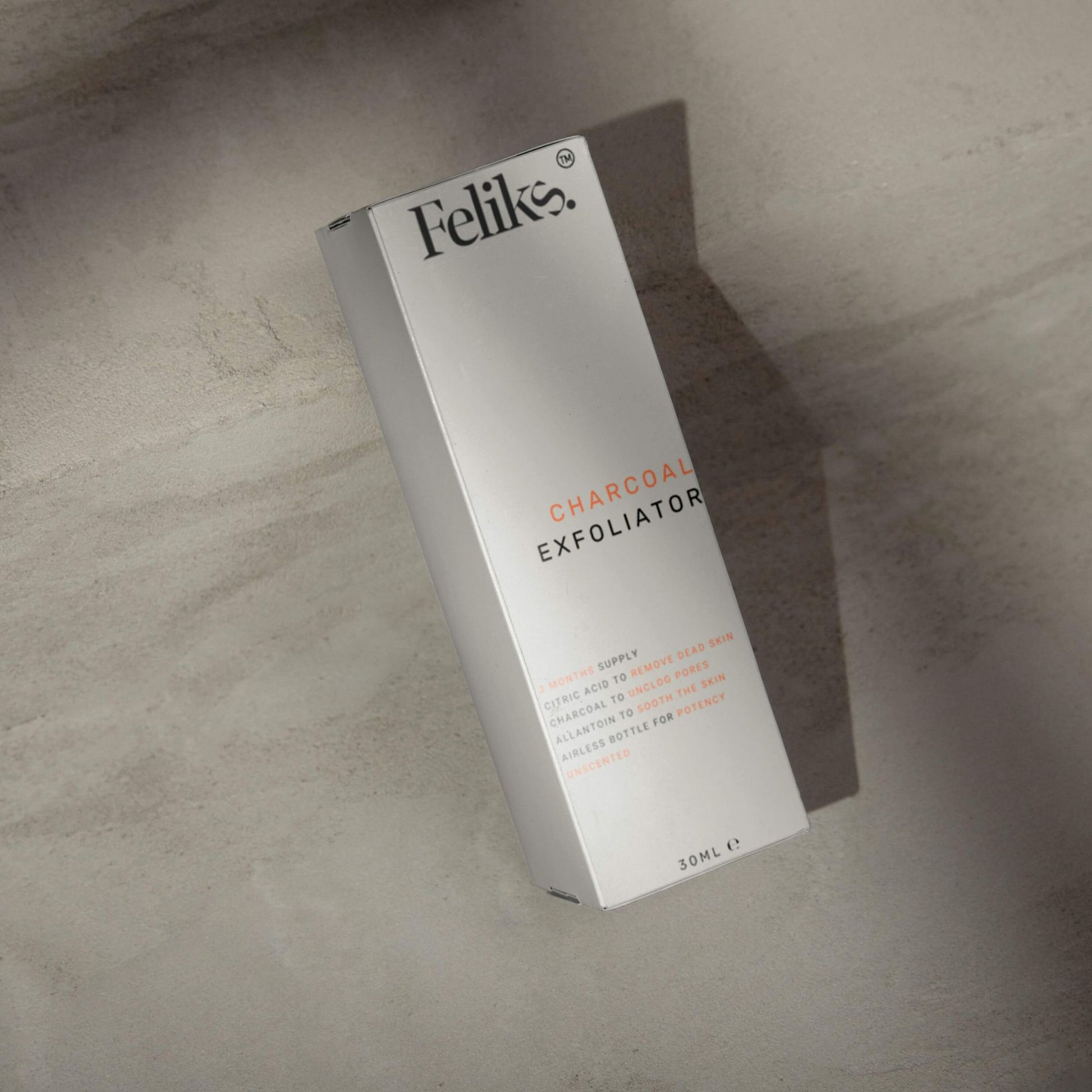 Feliks Charcoal Exfoliator packaging on a textured surface
