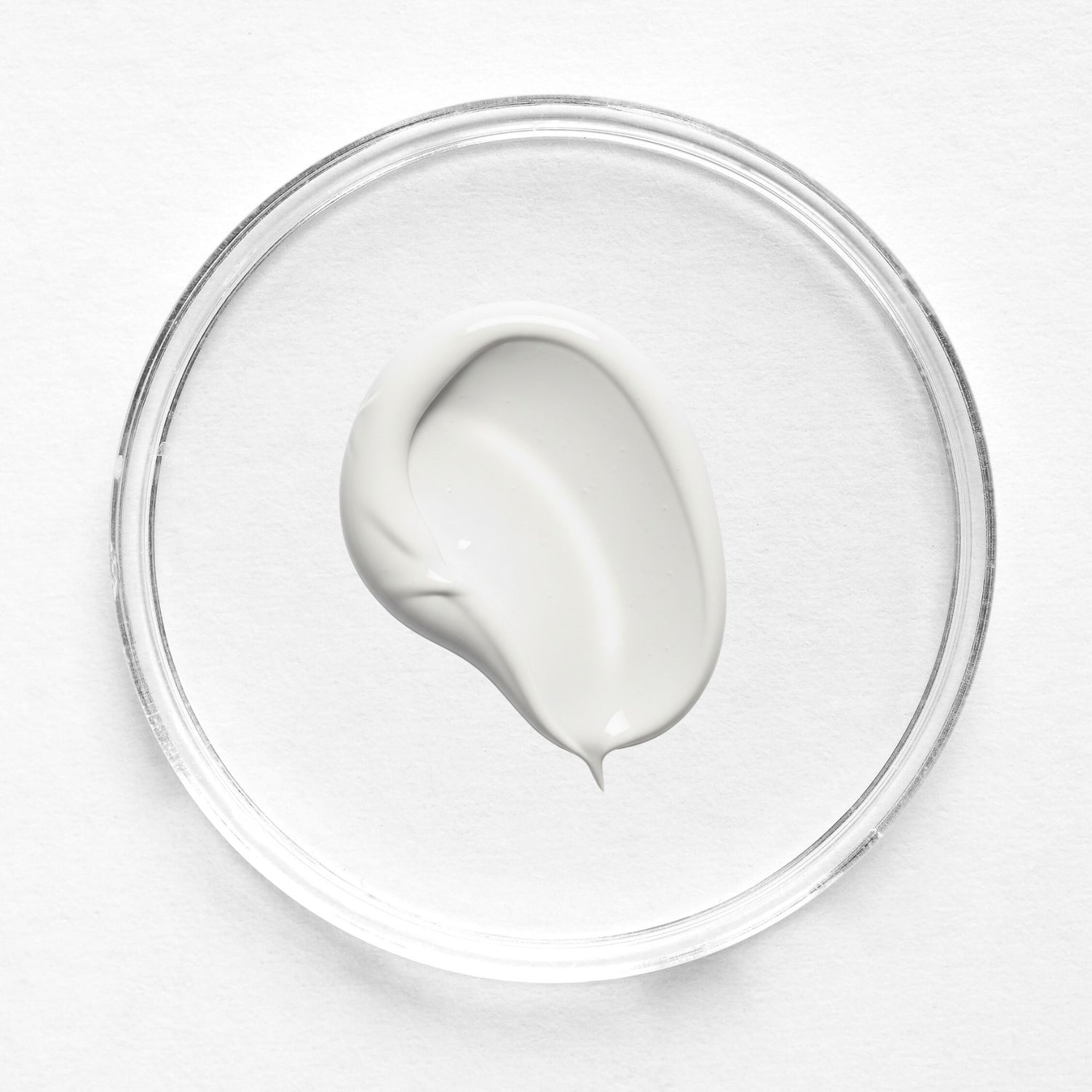 Feliks daily moisturiser sample in a clear glass petri dish on a white background